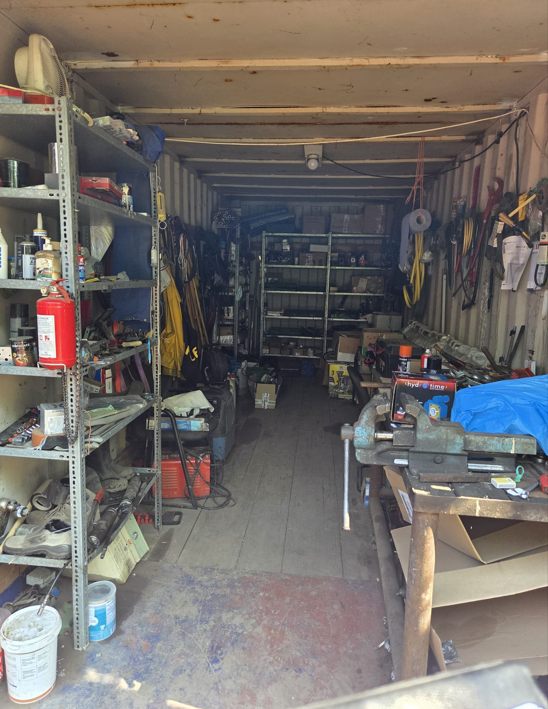 Shipping container fitted out as a workshop with tools and workbench